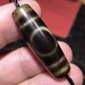 微信图片_20250916133551_47_4 高油一眼天地珠,尺寸13*38mm,玛瑙材质,油润度很高。Heaven-Earth Dzi Bead (13x38mm).