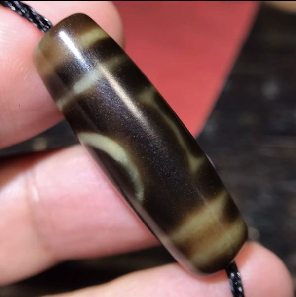 微信图片_20250916133555_48_4 高油一眼天地珠,尺寸13*38mm,玛瑙材质,油润度很高。Heaven-Earth Dzi Bead (13x38mm).